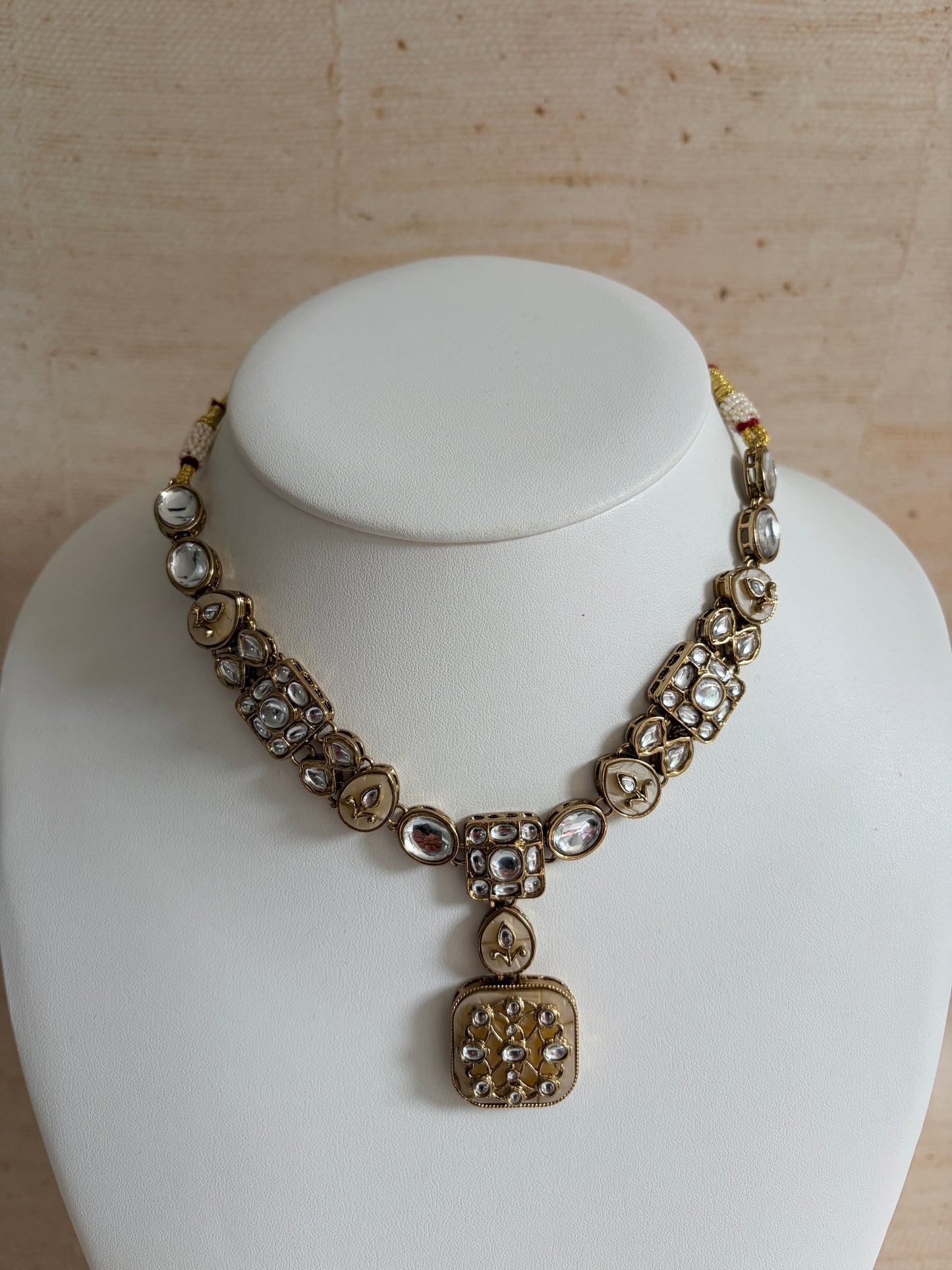 Decorative bracelet with intricate design on a white mannequin bust.