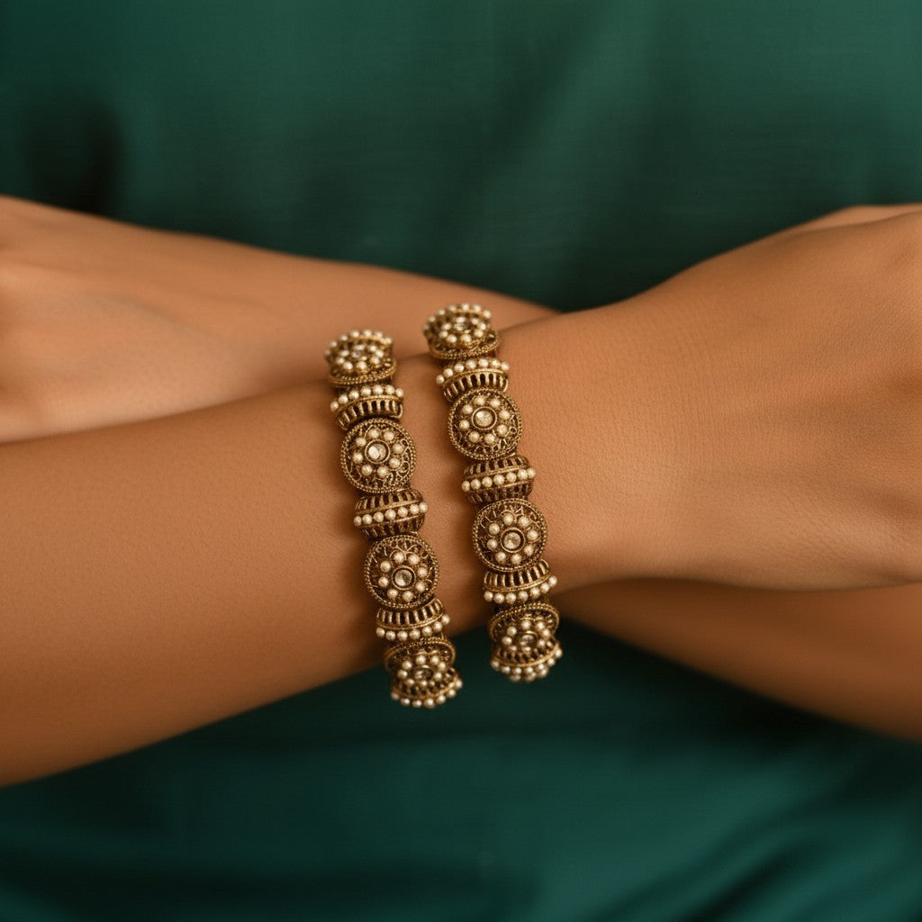 Gold bracelet on a wrist with a green background