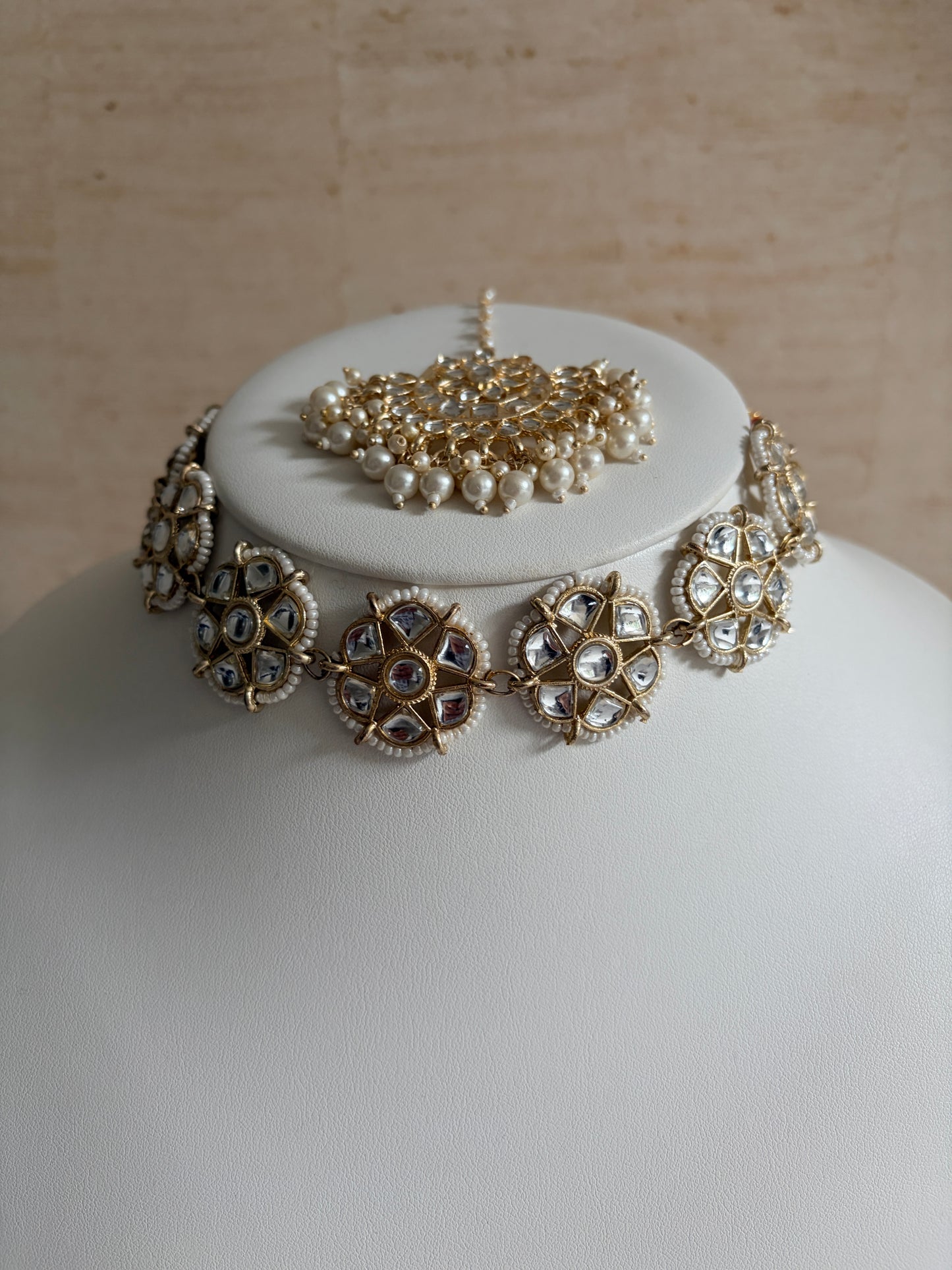 Jewelry set on a mannequin head with a neutral background