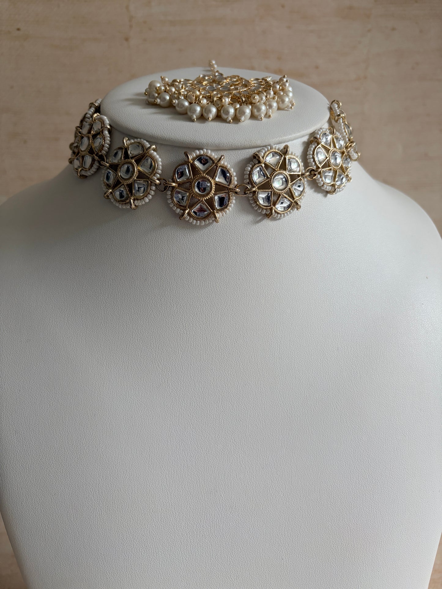 Decorative earrings on a mannequin head with a neutral background