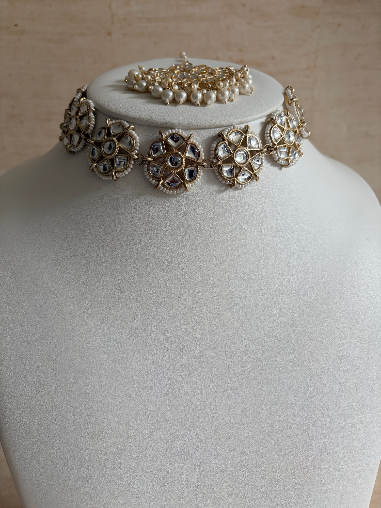 Decorative earrings on a mannequin head with a neutral background