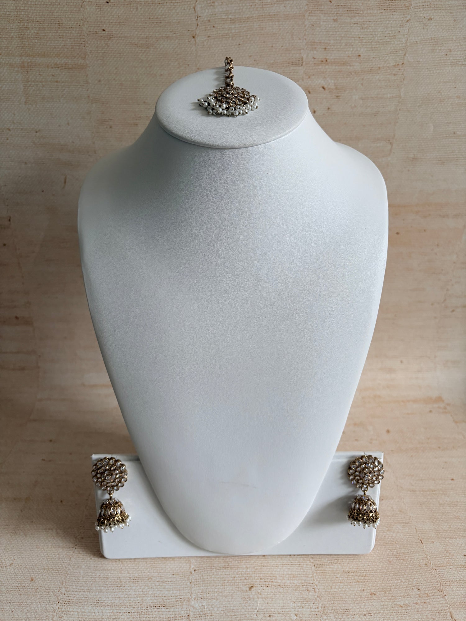 White vase with decorative elements on a beige background