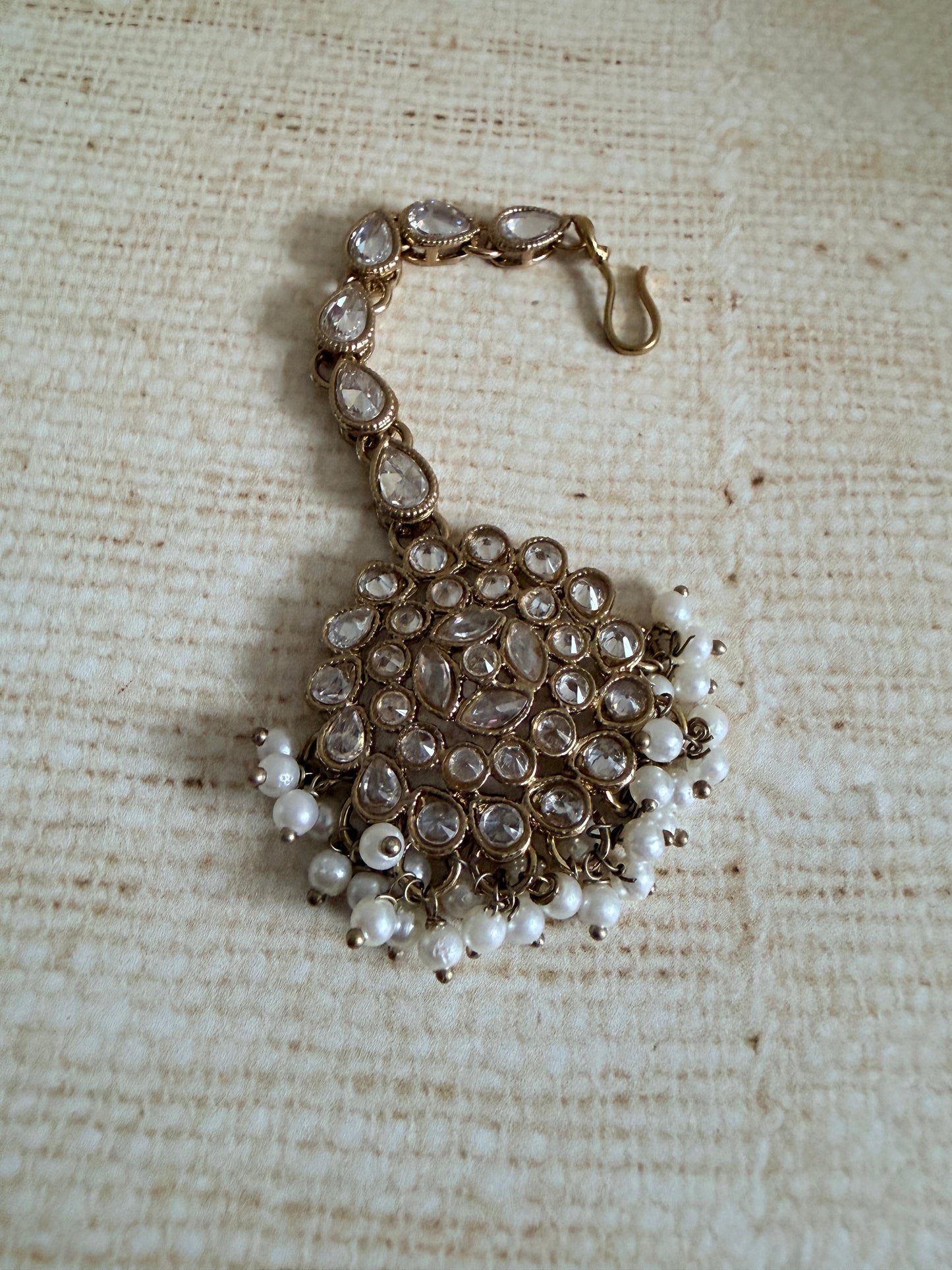 Beaded bracelet with pearls on a textured beige fabric background