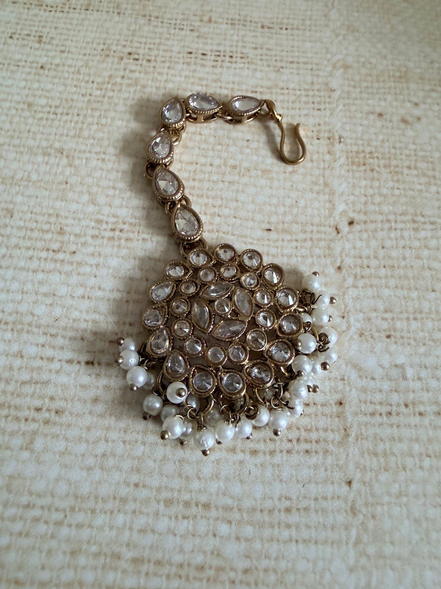 Beaded bracelet with pearls on a textured beige fabric background