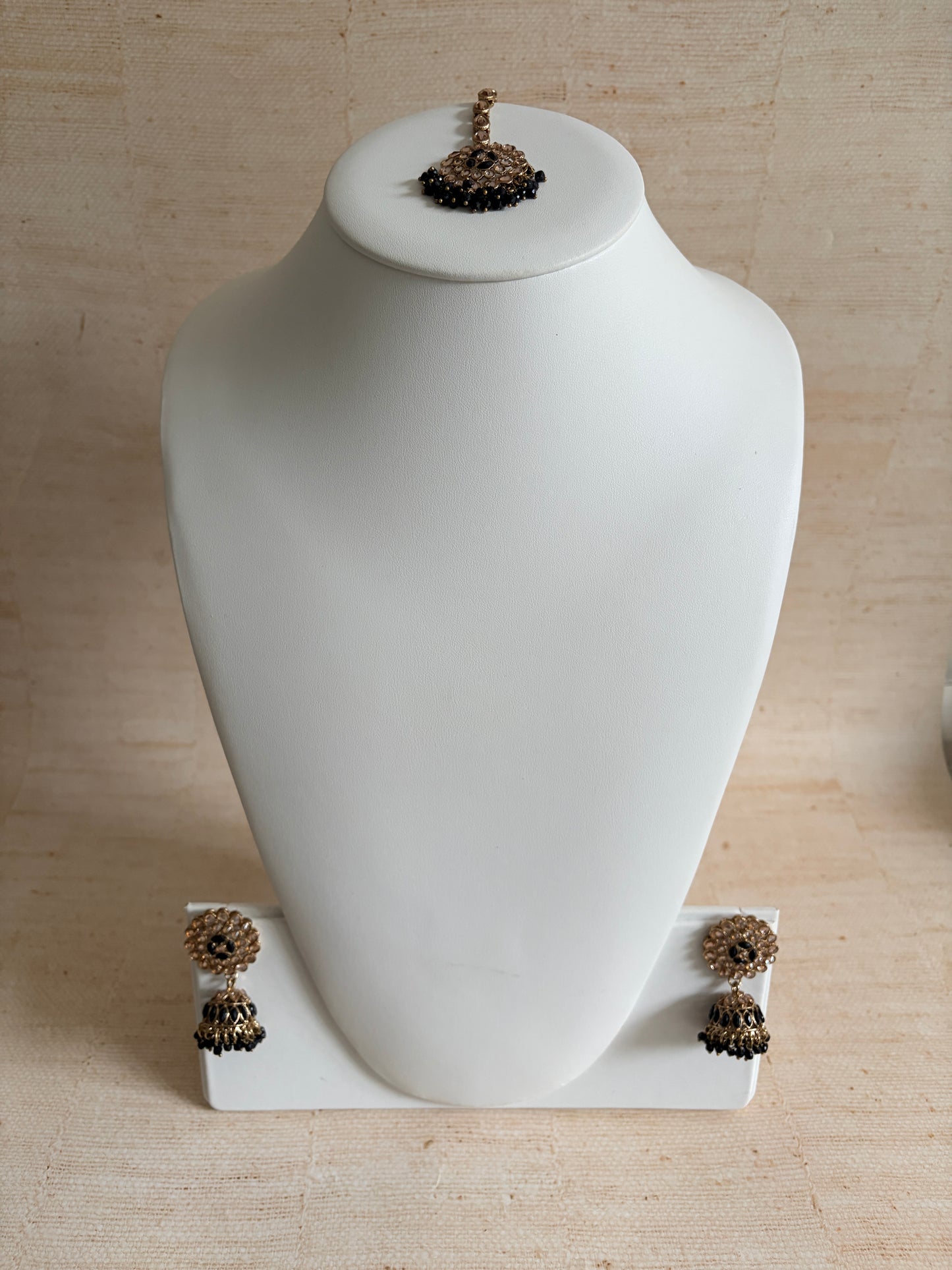 White decorative object with brown embellishments on a beige wall