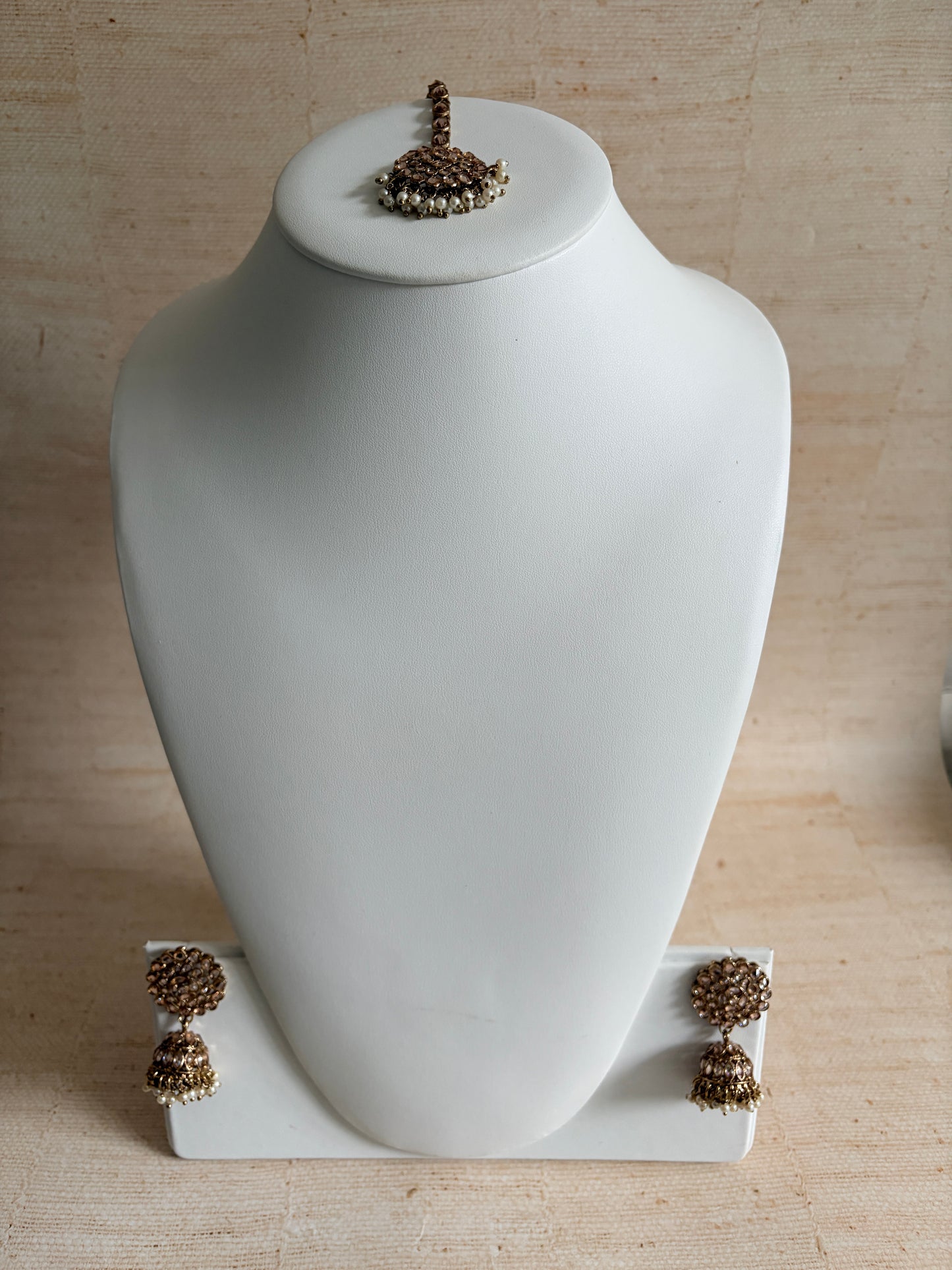 White wall-mounted lamp with decorative elements on a beige wall