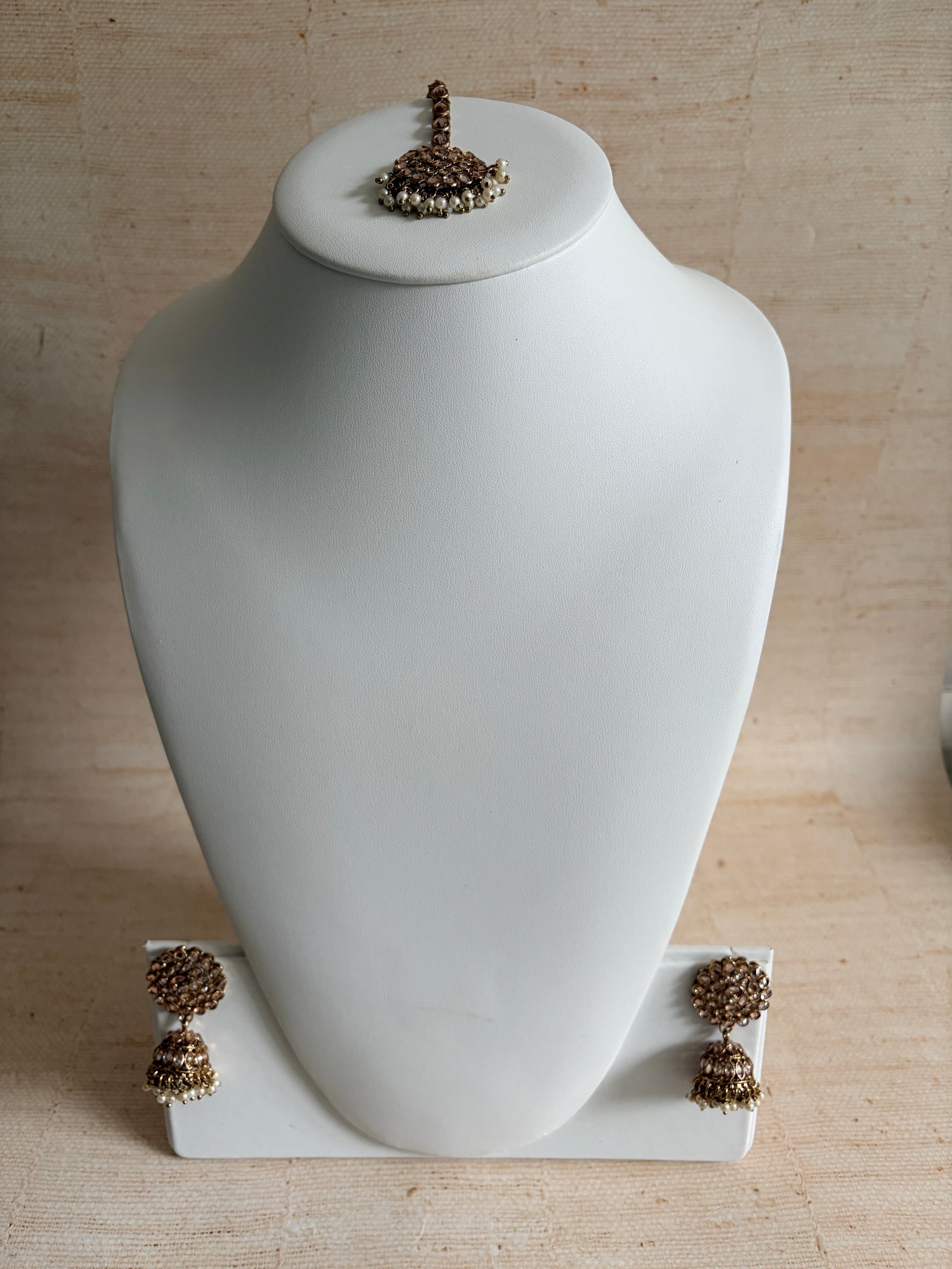 White wall-mounted lamp with decorative elements on a beige wall