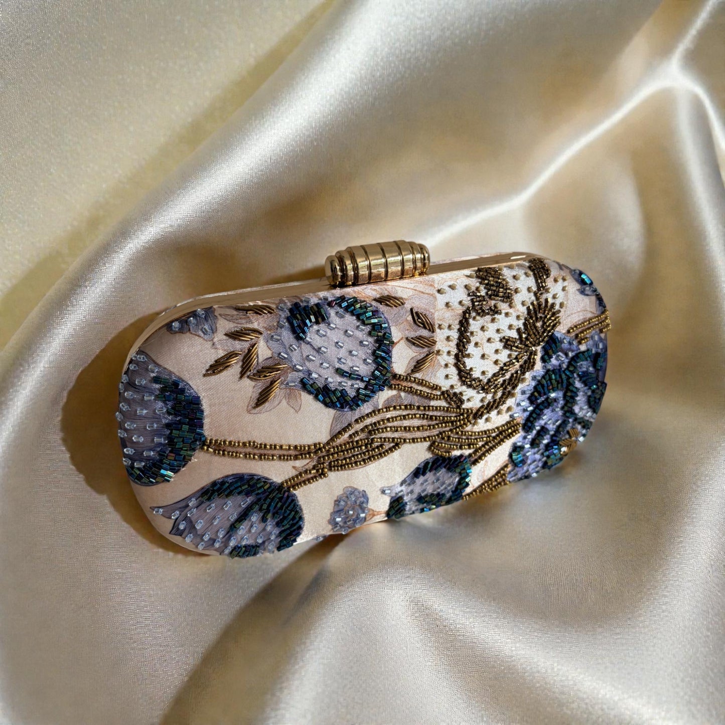 Decorative clutch bag with floral patterns on a satin surface