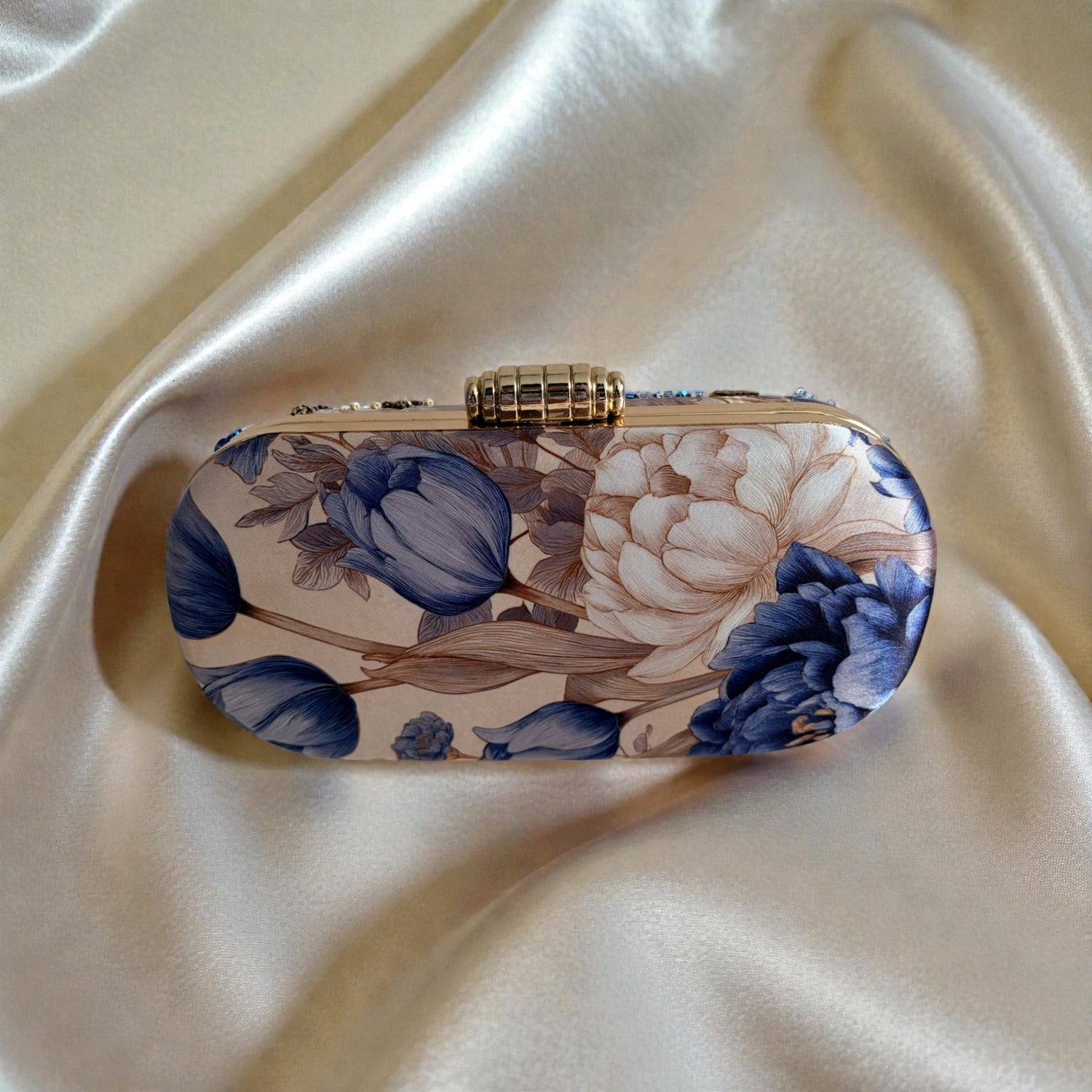 Floral patterned clutch bag on a satin surface