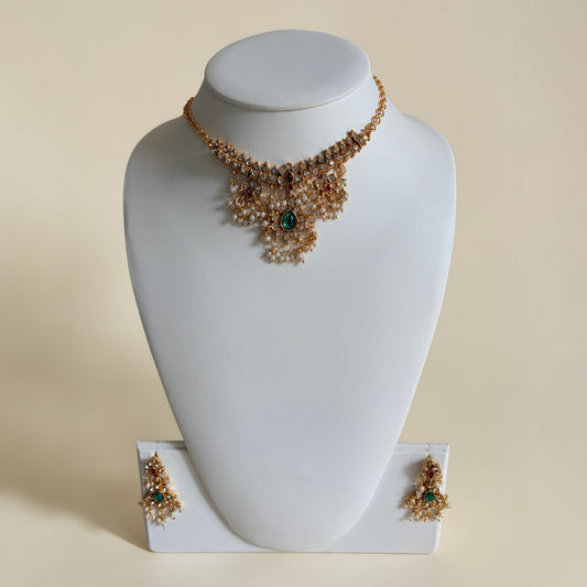 Necklace and earrings set on a white mannequin bust with a beige background