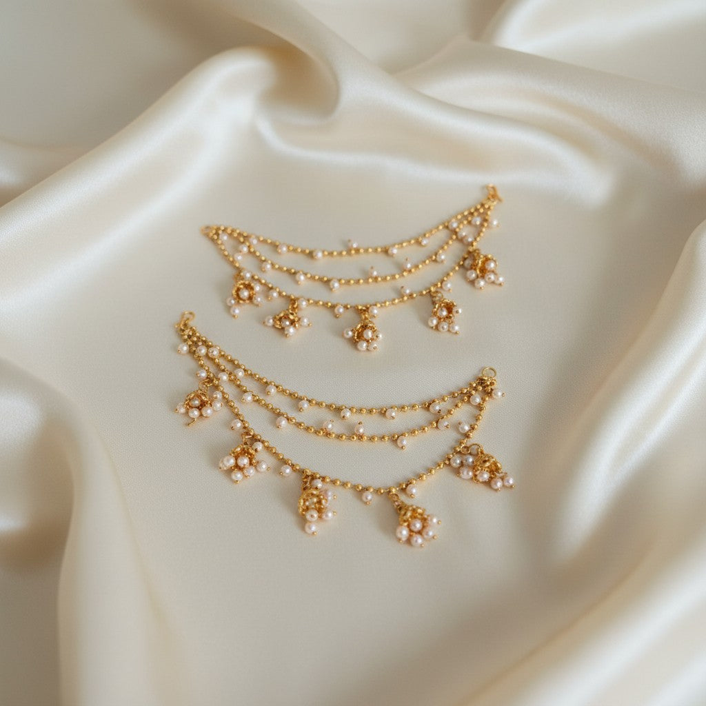 Gold necklace with floral pendants on a white fabric background