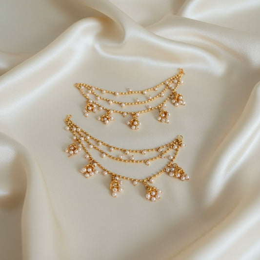 Gold necklace with floral pendants on a white fabric background
