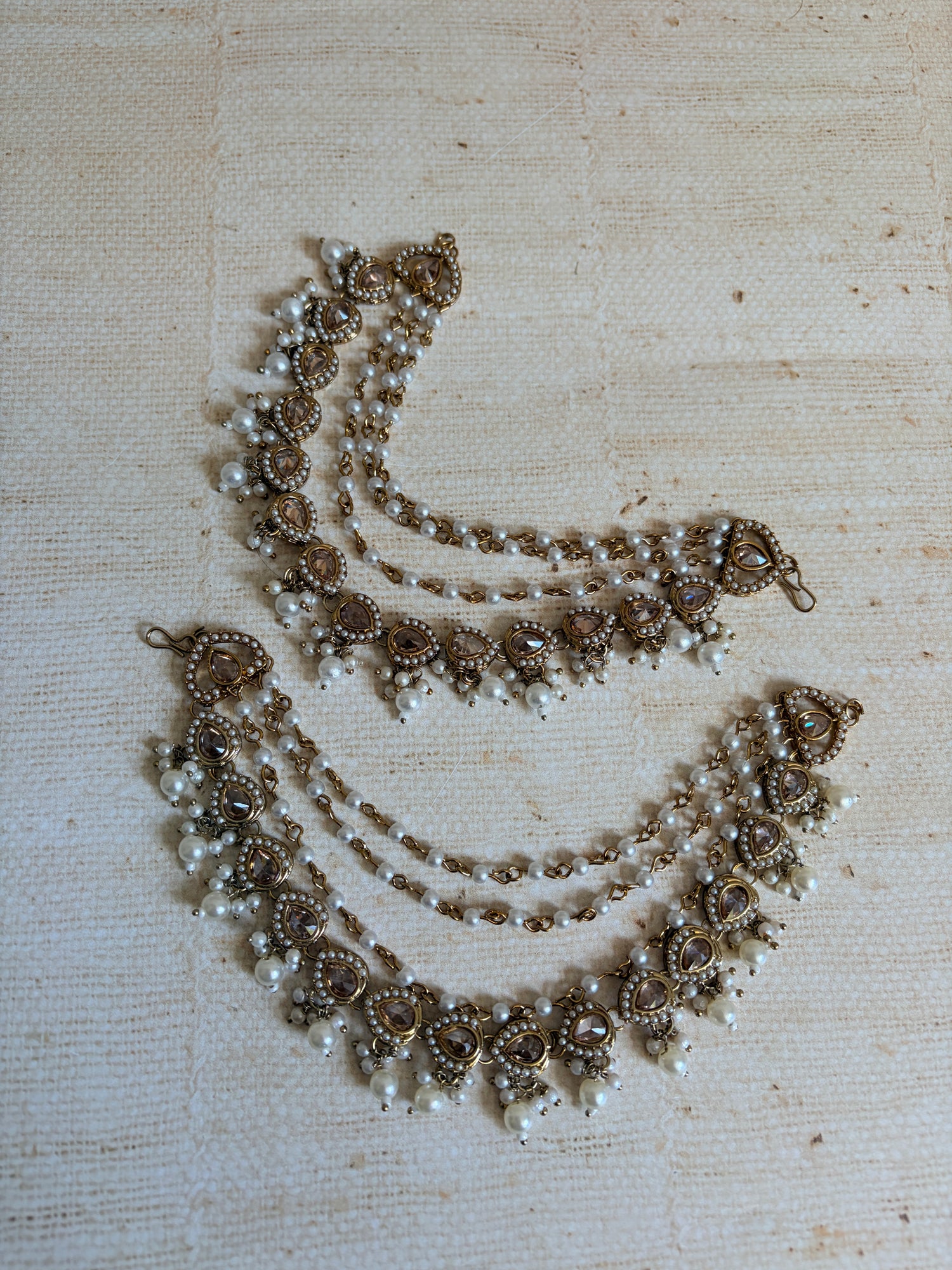 Decorative necklace with pearls on a textured beige background