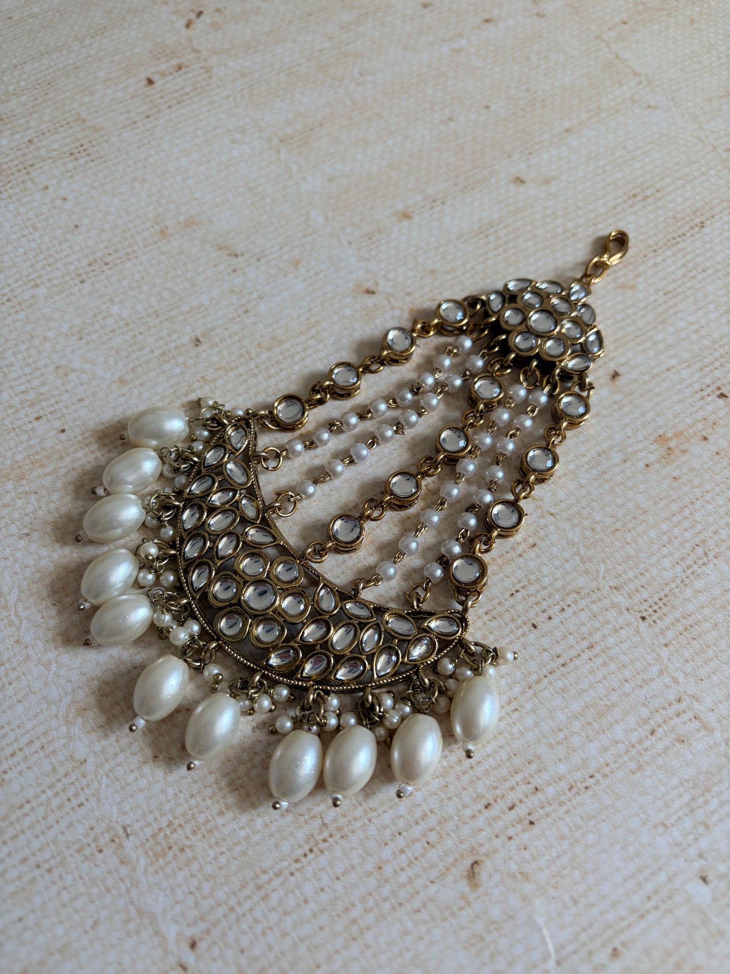 Decorative necklace with pearls on a textured beige background