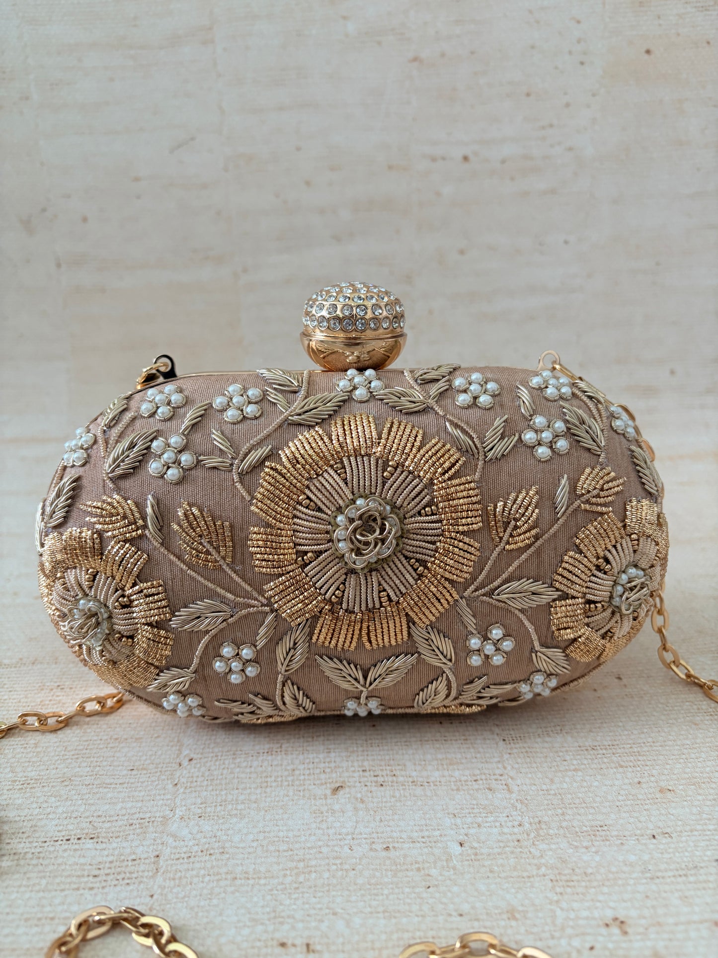 Decorative clutch bag with floral embroidery on a light background