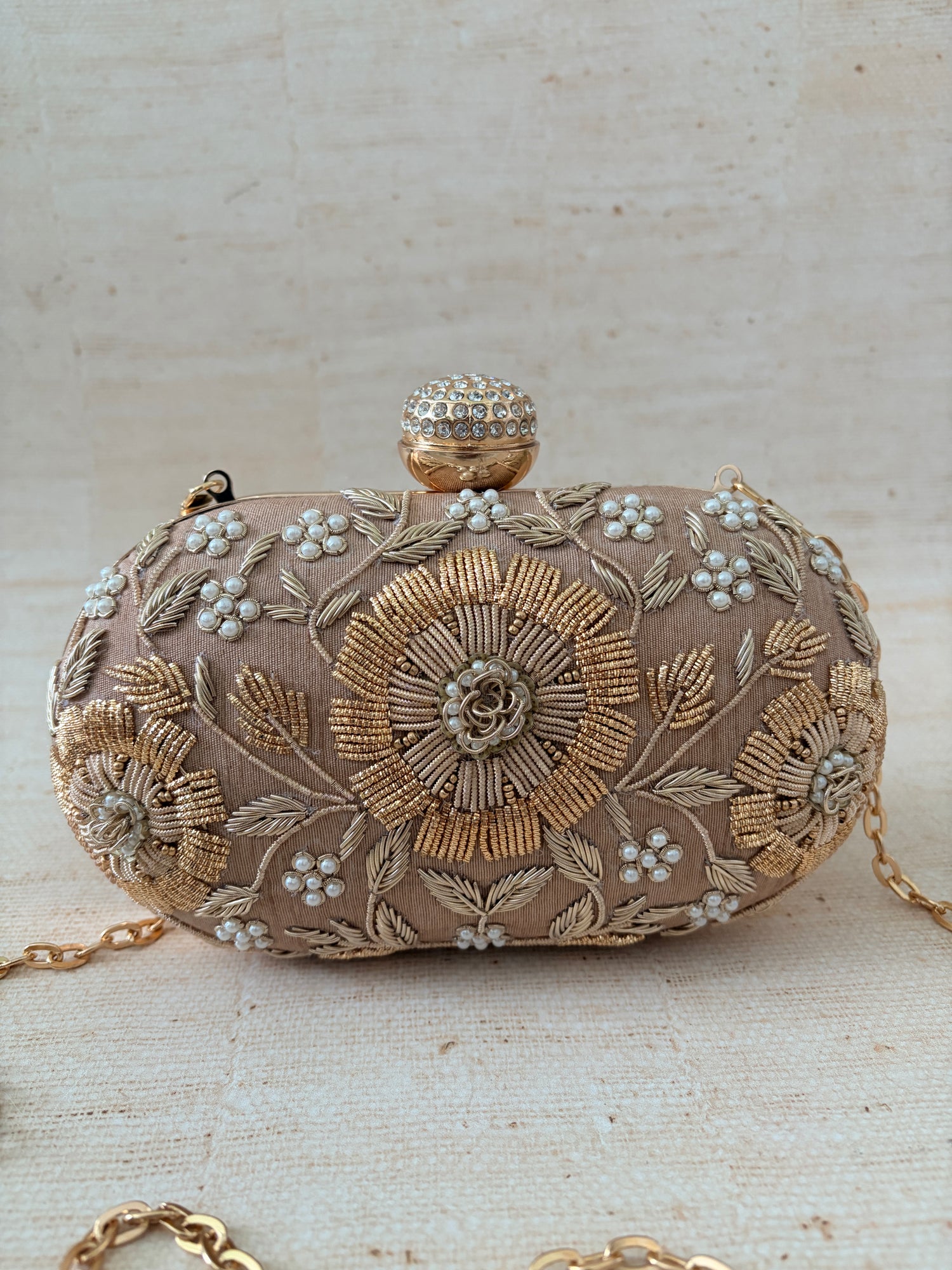 Decorative clutch bag with floral embroidery on a light background