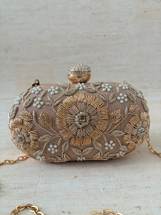 Decorative clutch bag with floral embroidery on a light background