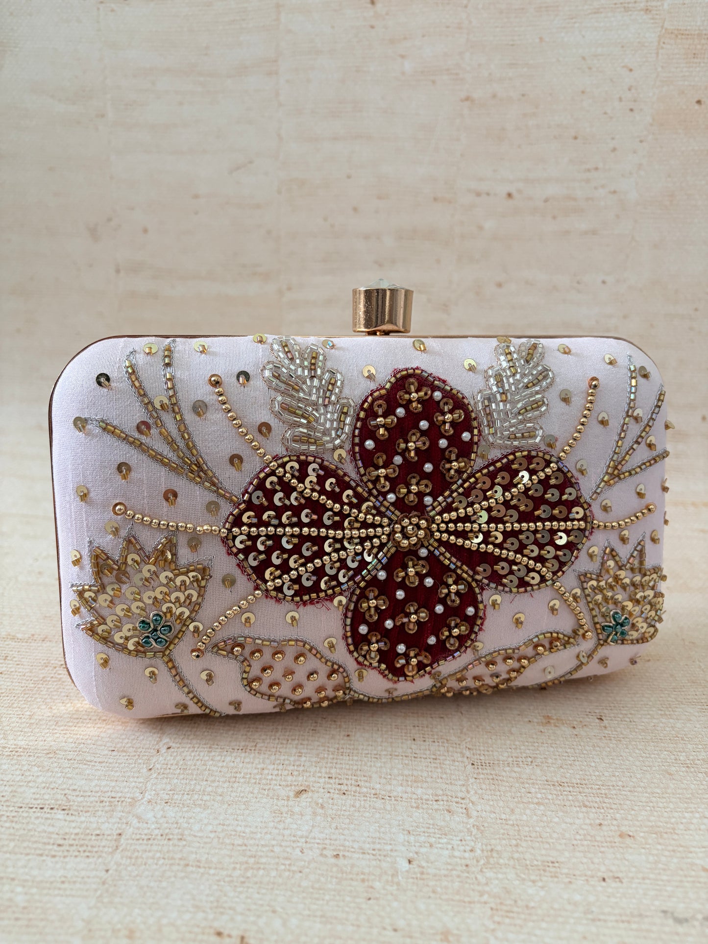 Decorative phone case with floral design and embellishments on a beige background