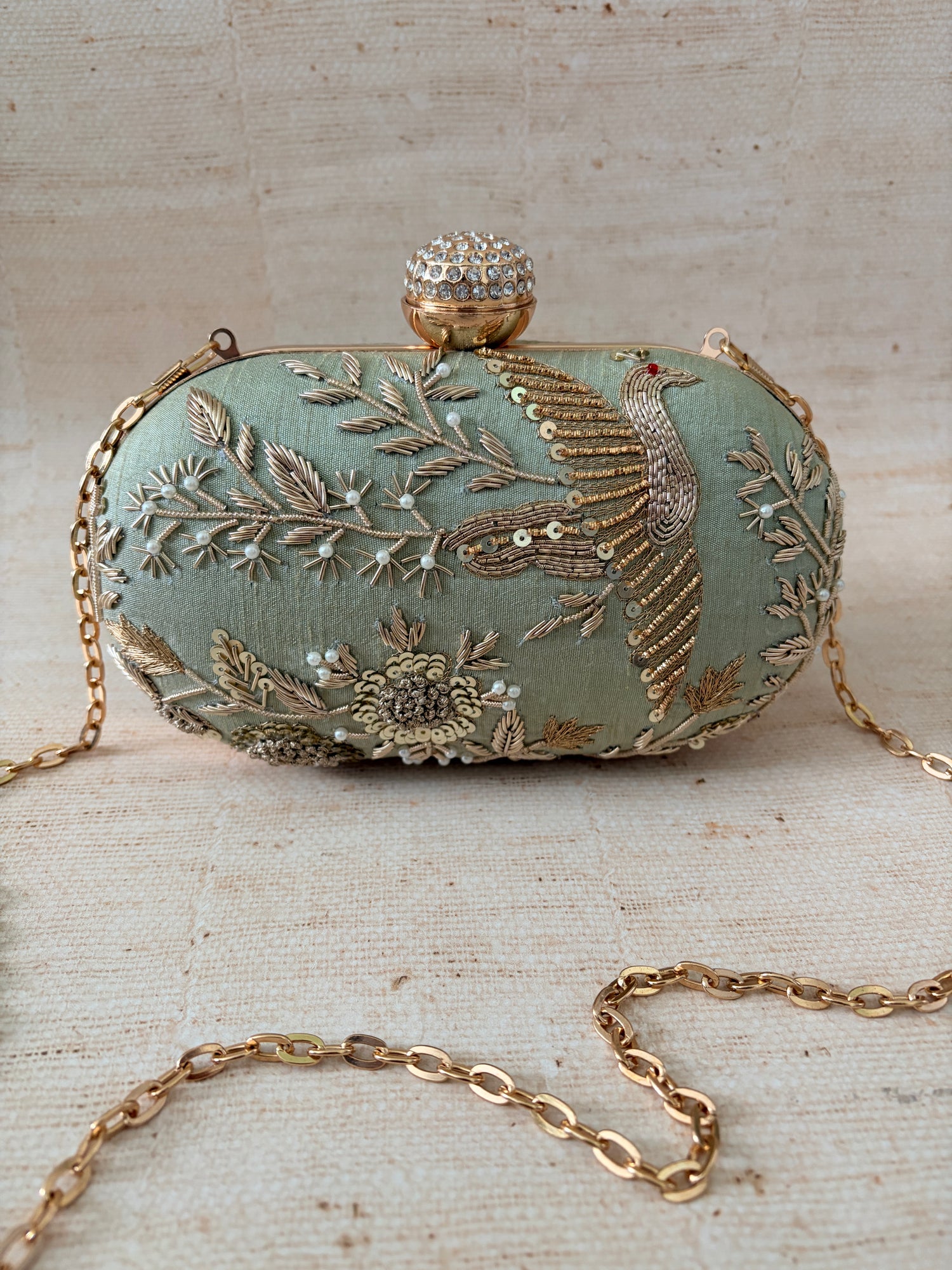 Decorative clutch with floral embroidery on a textured surface