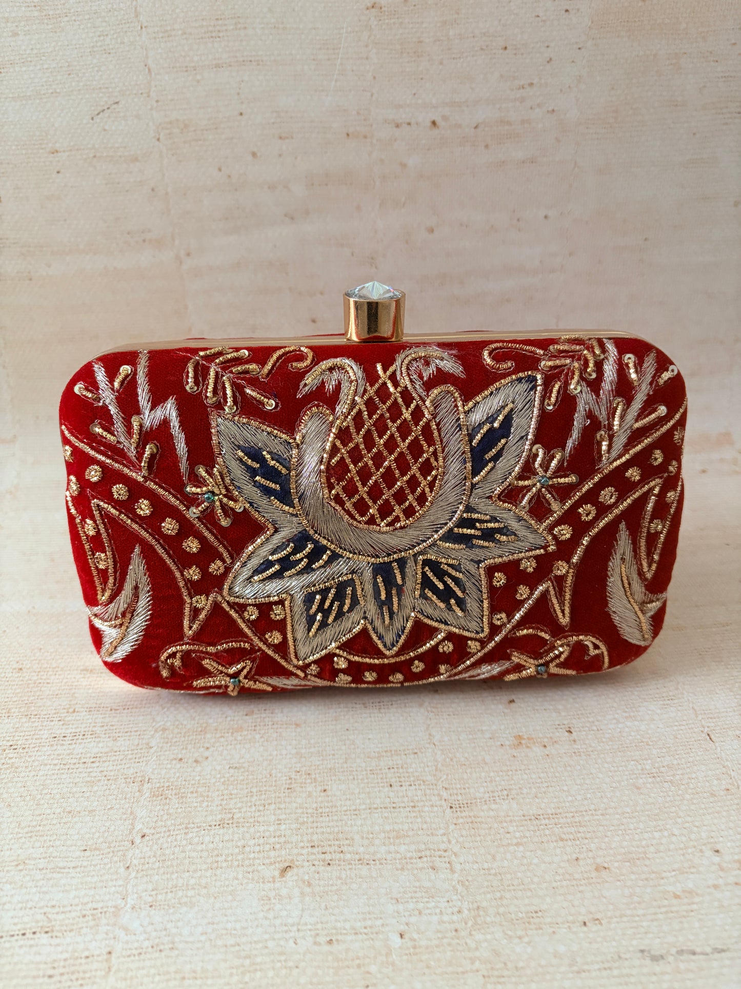 Rectangular clutch with floral embroidery on a beige background