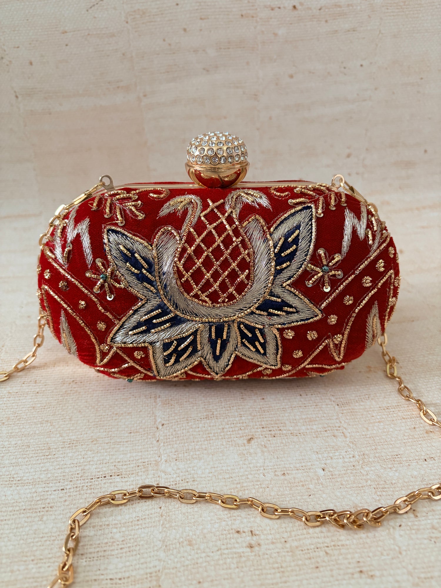 Decorative clutch bag with floral embroidery on a textured surface