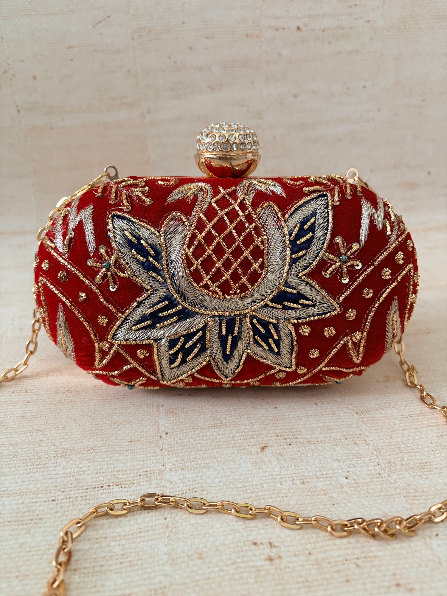 Decorative clutch bag with floral embroidery on a textured surface