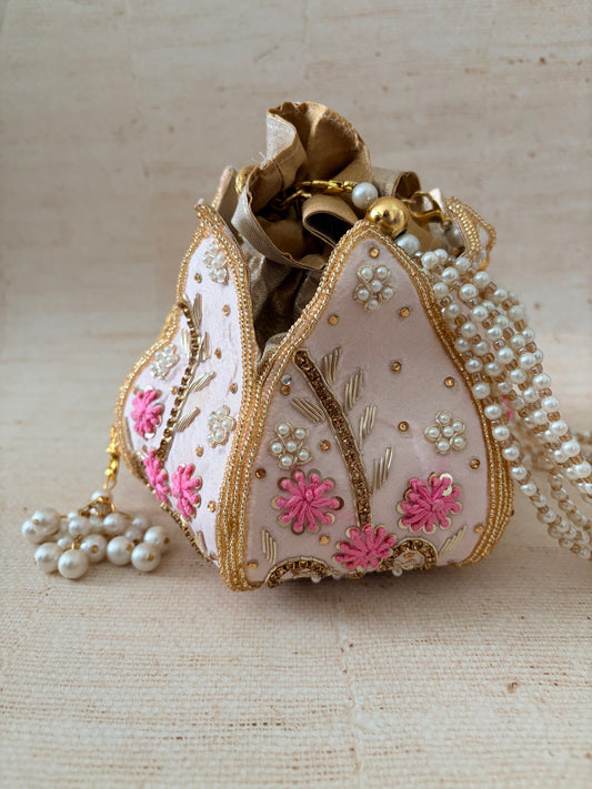 Decorative heart-shaped box with floral patterns and pearl embellishments on a beige background