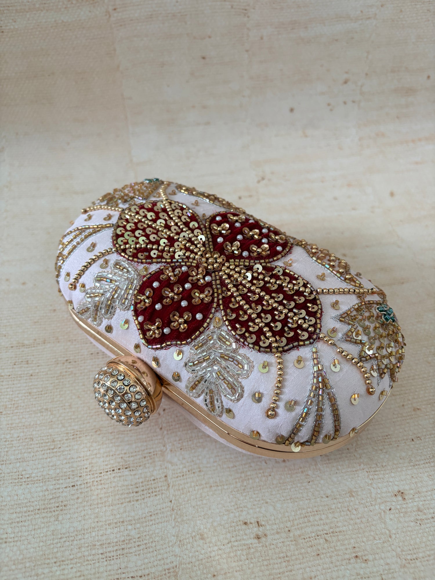 Decorative brooch with butterfly design on a beige fabric background