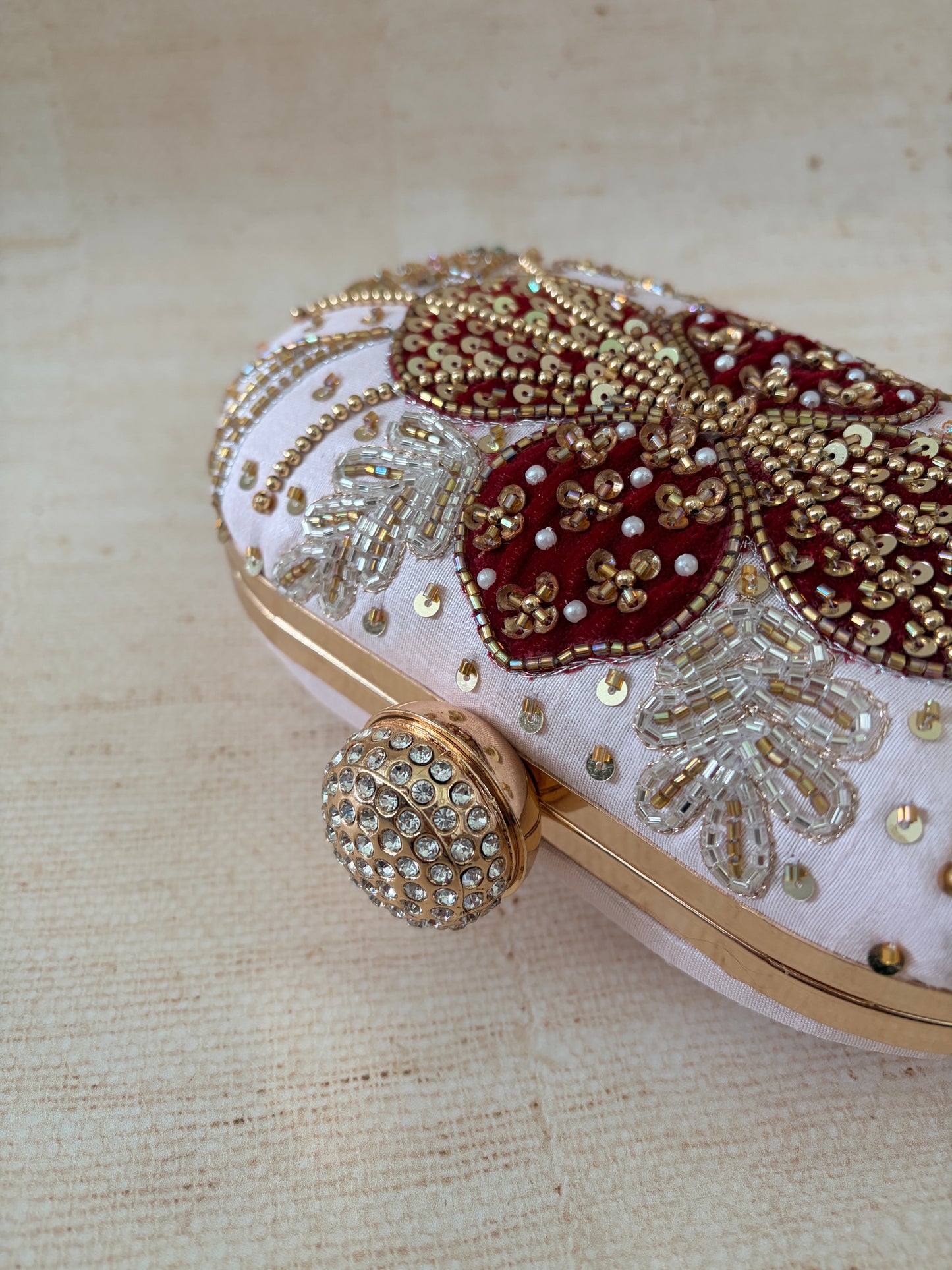 Decorative shoe with gold and red embellishments on a beige background