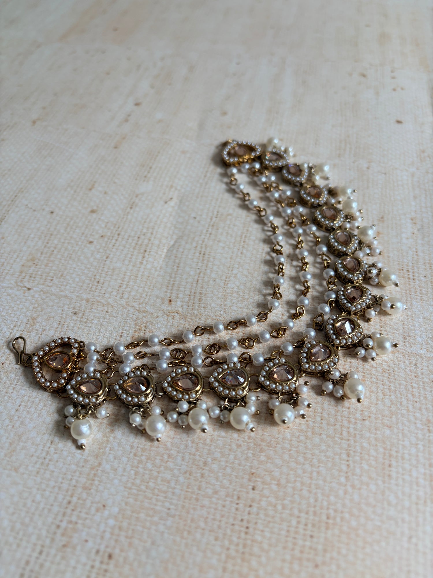 Pearl and crystal bracelet on a textured beige surface