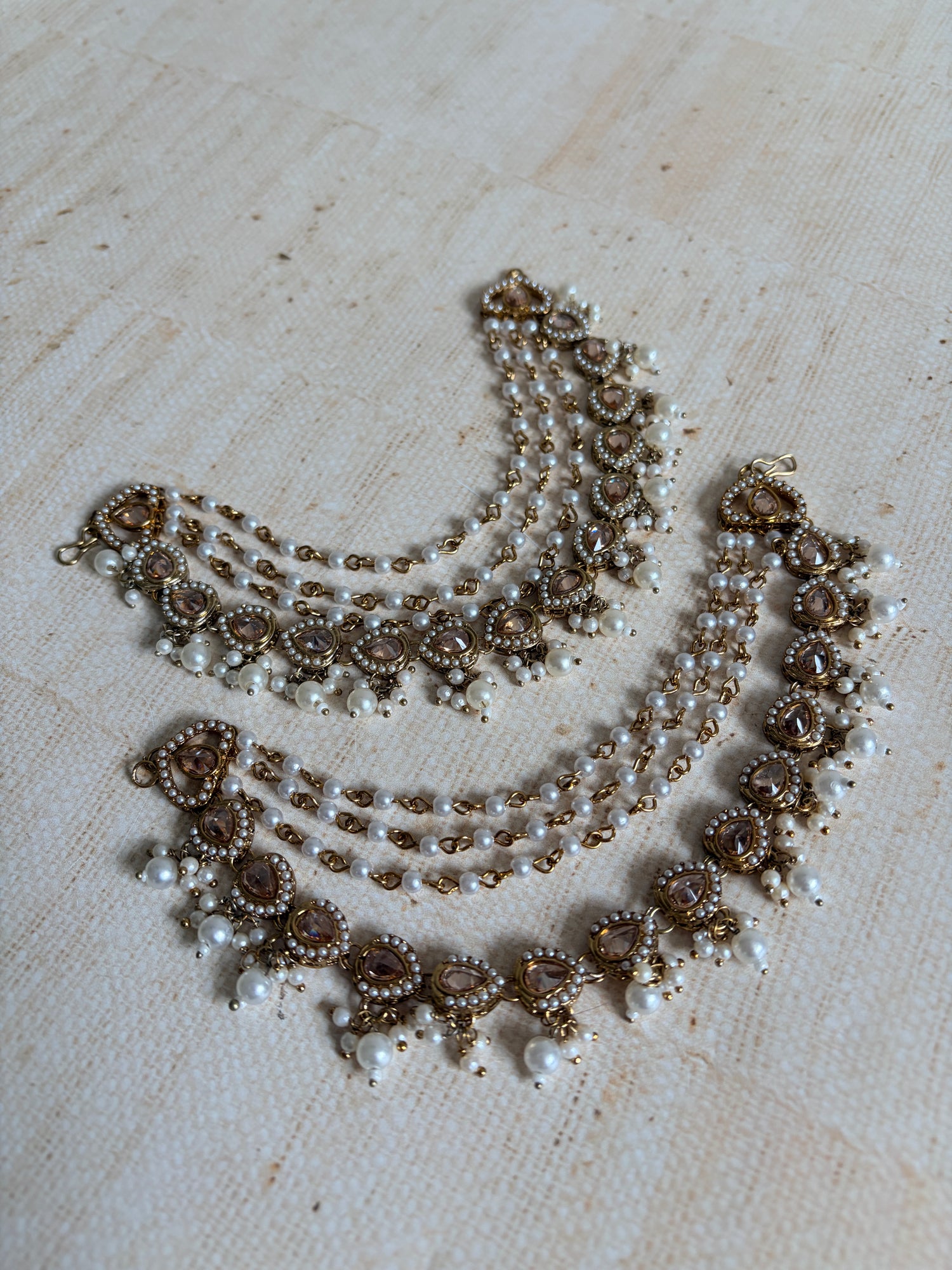 Decorative necklace with pearls and brown beads on a light wooden surface