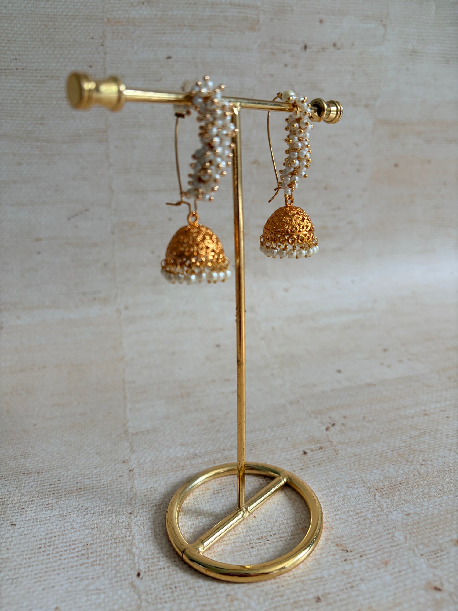 Gold brooch with floral design on a textured beige background