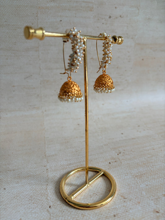 Gold brooch with floral design on a textured beige background