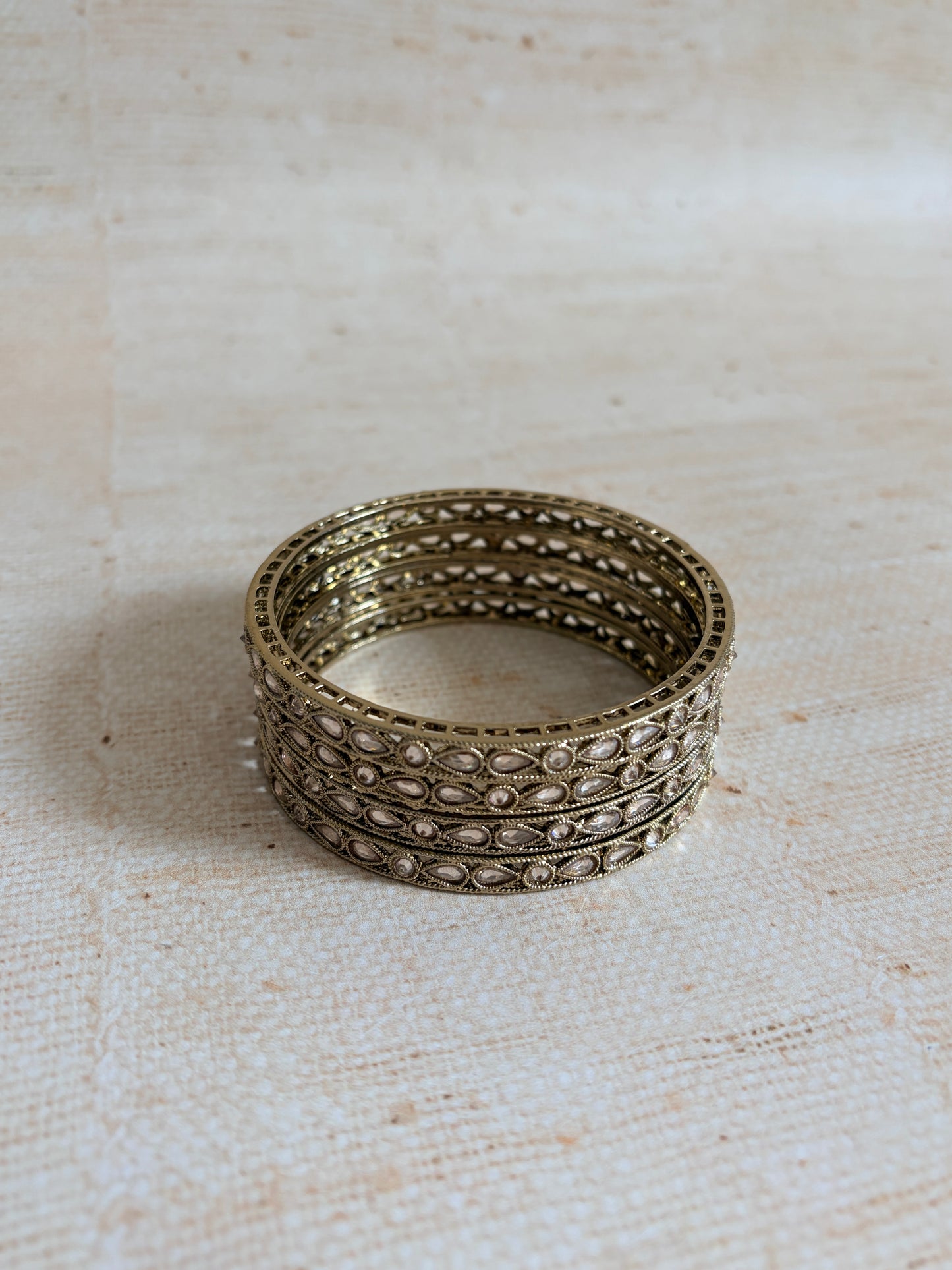 Silver ring with intricate design on a textured beige background