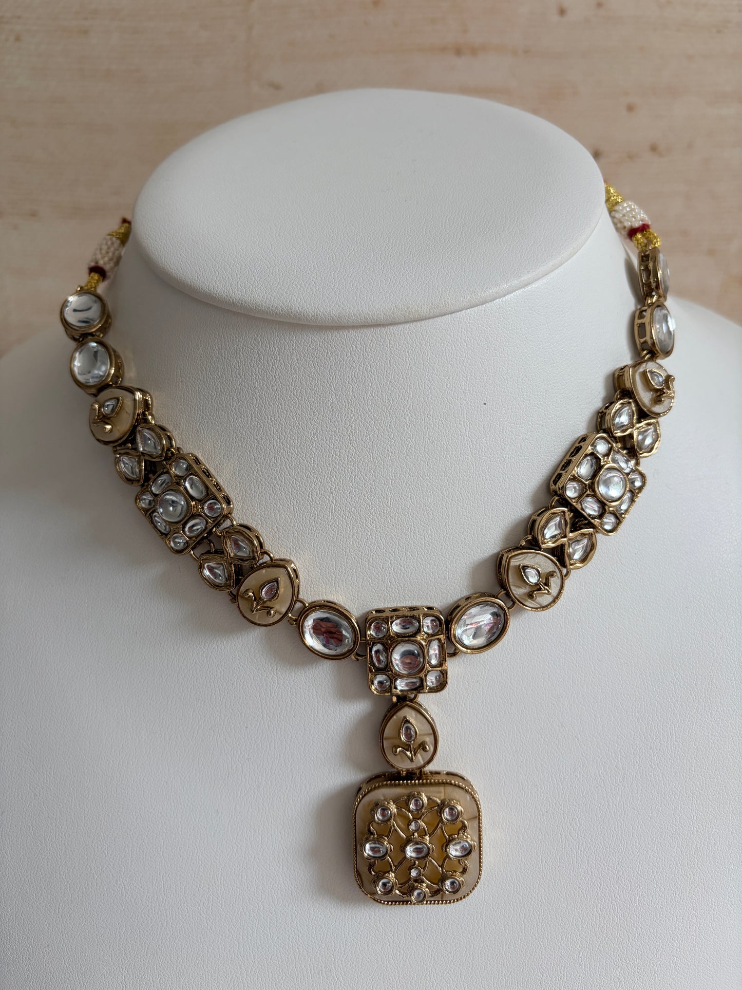 Gold bracelet with gemstones on a white mannequin arm