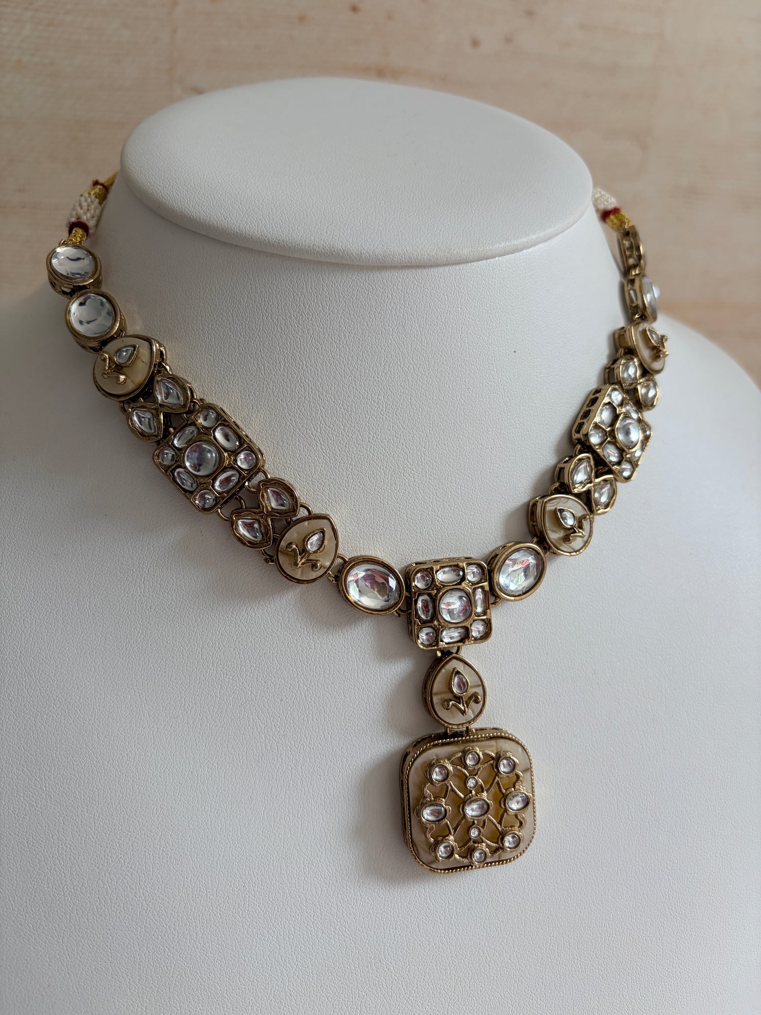 Gold bracelet with gemstones on a white mannequin bust