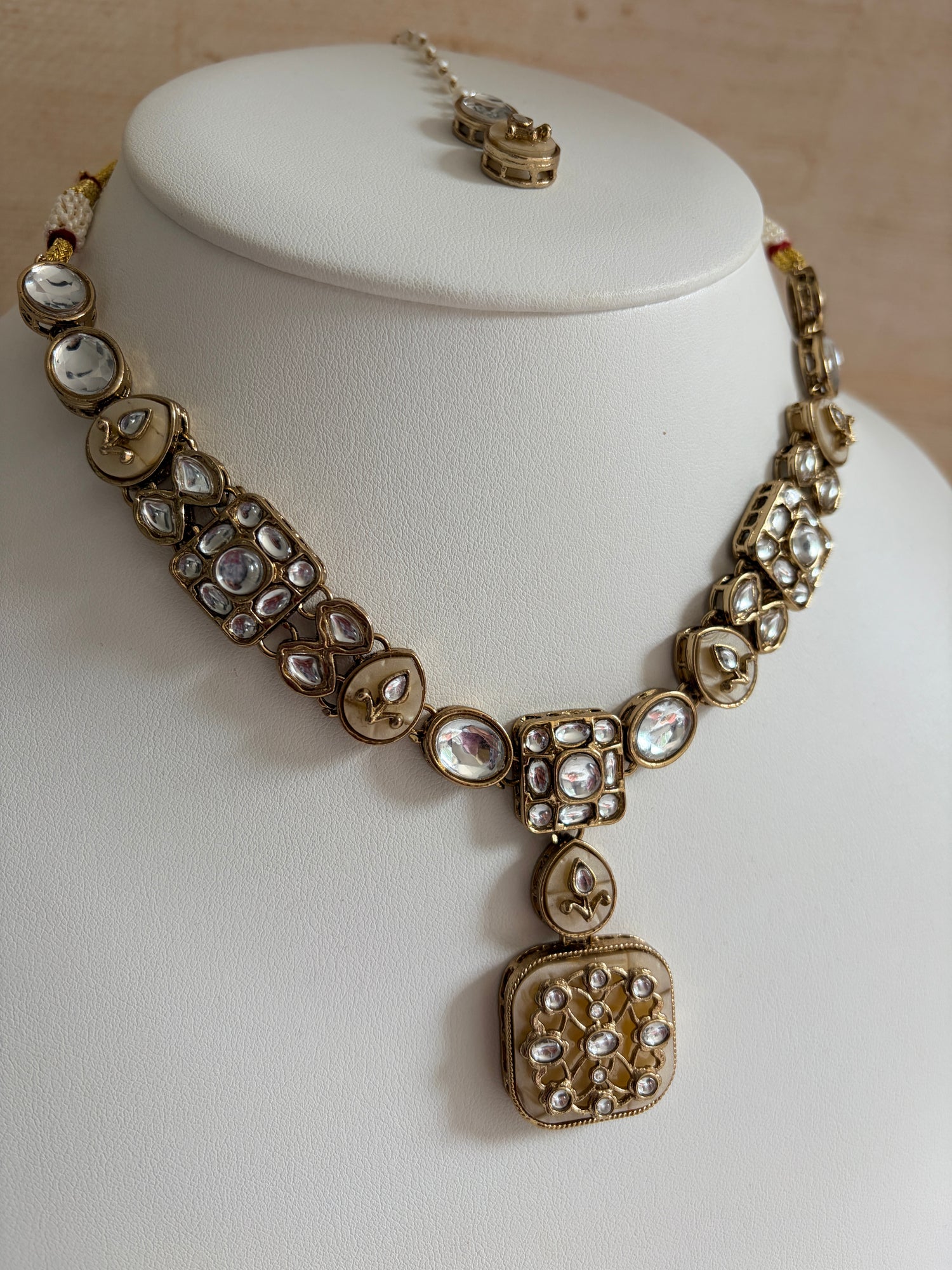 Gold bracelet with gemstones on a white mannequin bust