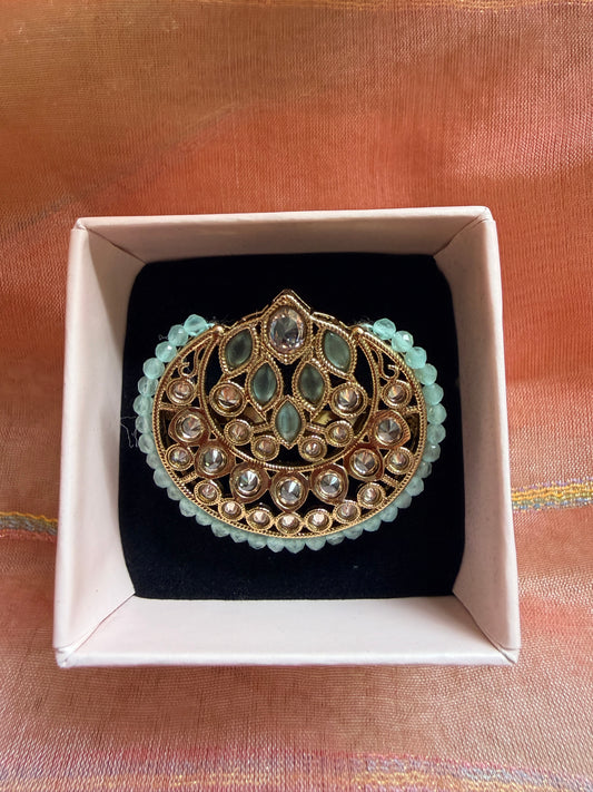 Decorative brooch in a box on a textured fabric background